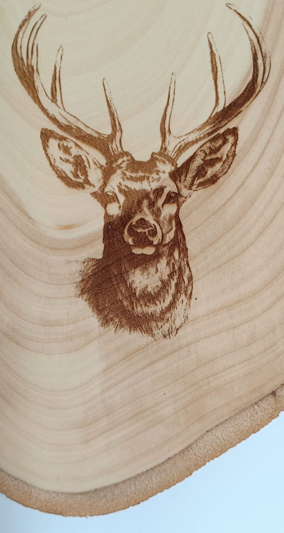 Dřevěné nástěnné hodiny "Jelen" s vygravírovaným motivem.