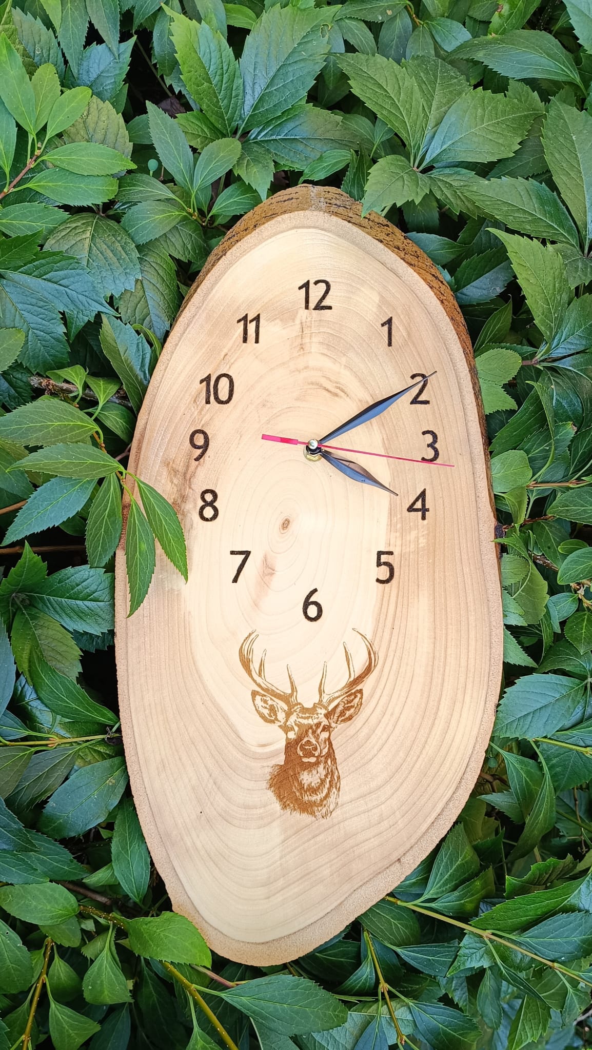 Dřevěné nástěnné hodiny "Jelen" s vygravírovaným motivem.